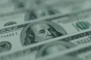 Bitunix Close-up view of several U.S. 100 dollar bills, prominently showing Benjamin Franklin’s portrait. The image has a shallow focus, drawing attention to the central bill—an interesting contrast to intangible assets like blockchain.