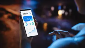 Bitunix A person holds a smartphone displaying a crypto wallet app with a ,357 balance, transaction details, and a rising financial graph, against a blurred city street background at night.