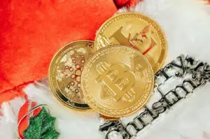 Bitunix Three gold cryptocurrency coins, including Bitcoin, are placed on a red and white Christmas-themed background with a Merry Christmas decoration and green holly accent, symbolizing festive cheer and the potential of staking during the holiday season.
