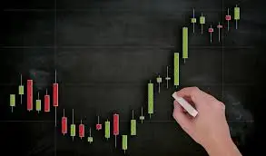 Bitunix A hand draws a candlestick chart with green and red bars on a blackboard, illustrating Spot & Futures Trading and representing financial or stock market data trends.