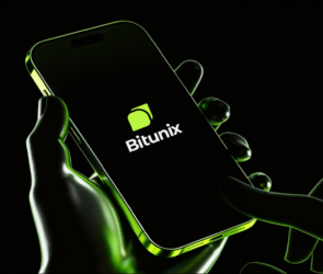 A hand holds a smartphone displaying the Bitunix app logo on the screen, with a green and black color scheme and a glowing effect highlighting the device and fingers.